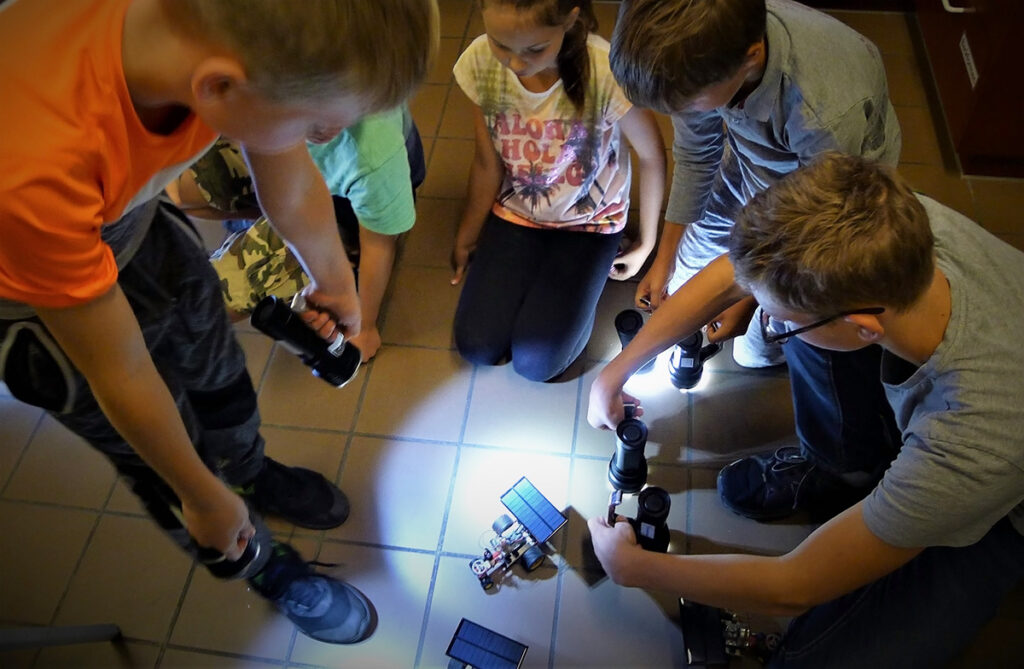 Kinder mit Solarauto und Taschenlampe